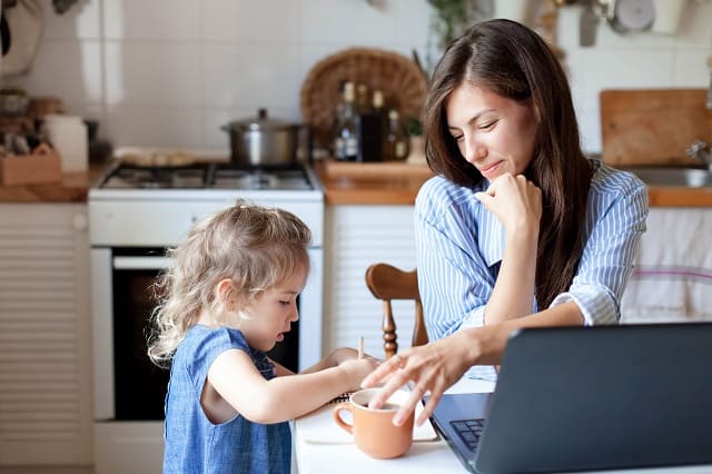 Las madres trabajadoras trabajan desde casa con sus hijos.  Mujer y niño lindo con laptop.