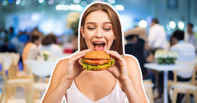 woman eating burger restaurant blue background
